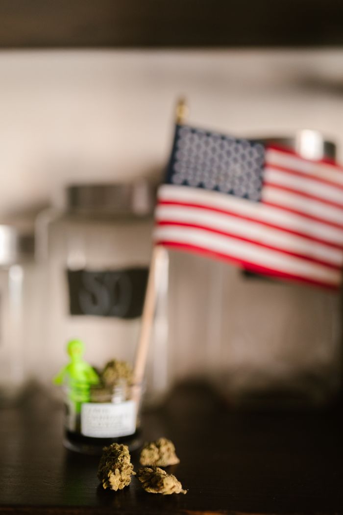Close-up of cannabis buds with an American flag in the background, highlighting US legalization.